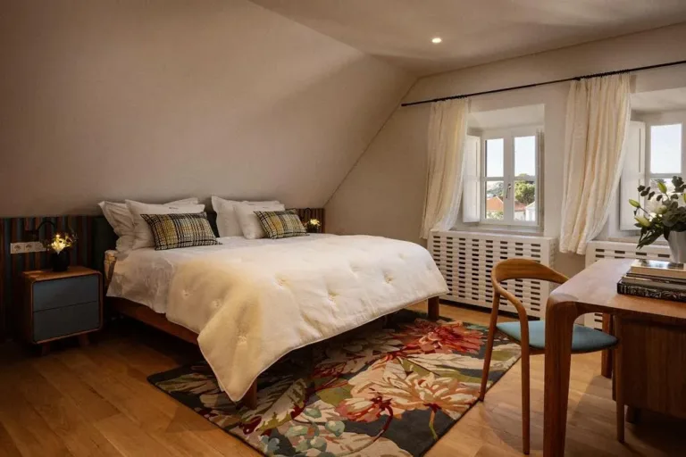 Bedroom with king-size bed and colourful rug at Villa La Rose
