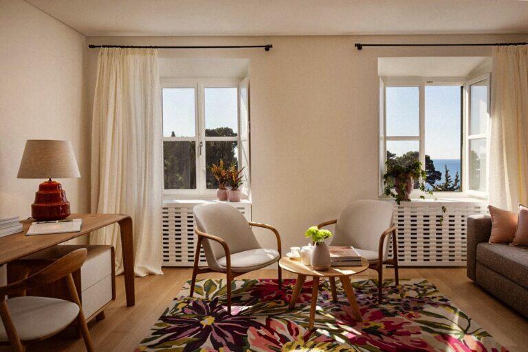 Schlafzimmer mit Sitzecke mit Sesseln und Schreibtisch in Villa La Rose