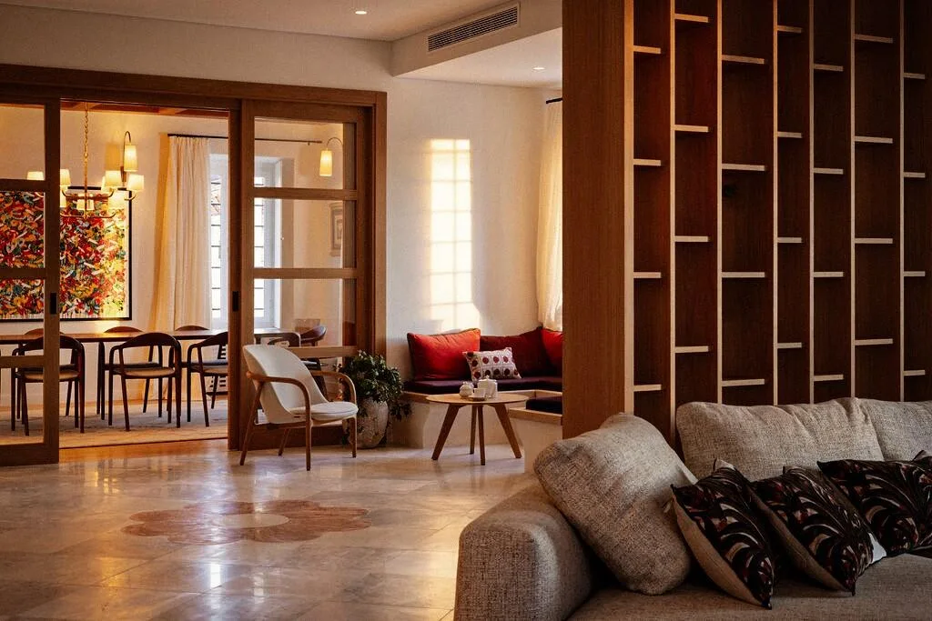 Living room with sofa and wooden screen leading to dining at Villa La Rose