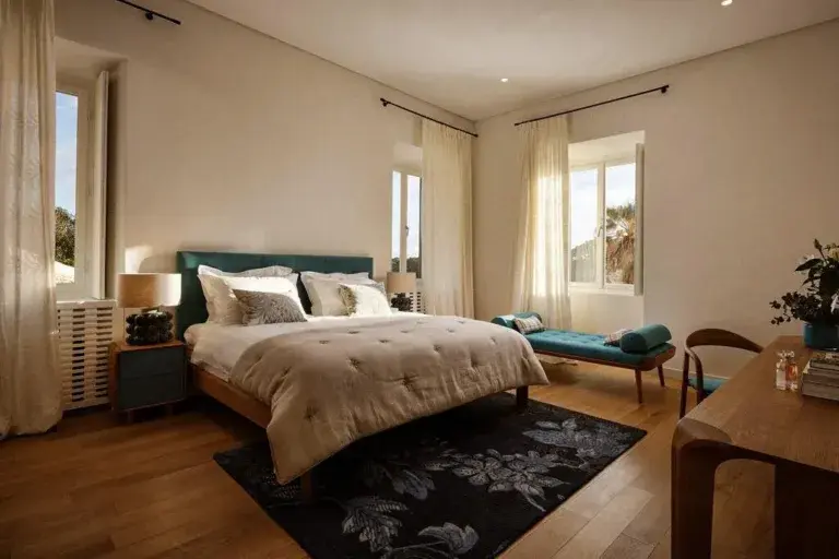 Bedroom with king-size bed and teal headboard at Villa La Rose