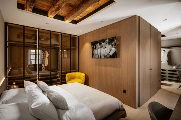 Schlafzimmer mit Kingsize-Bett und gelbem Sessel in der Villa Lapisa