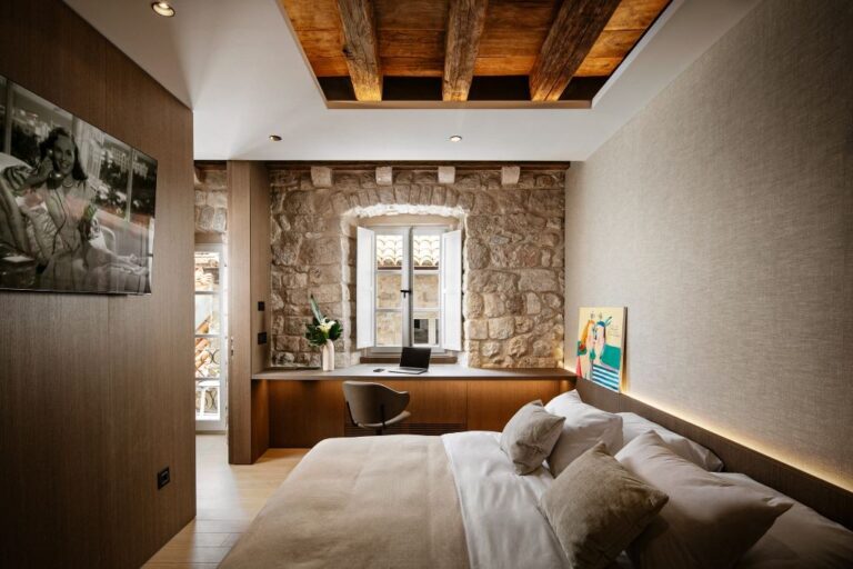 Schlafzimmer mit Kingsize-Bett unter Holzträgern in der Villa Lapisa