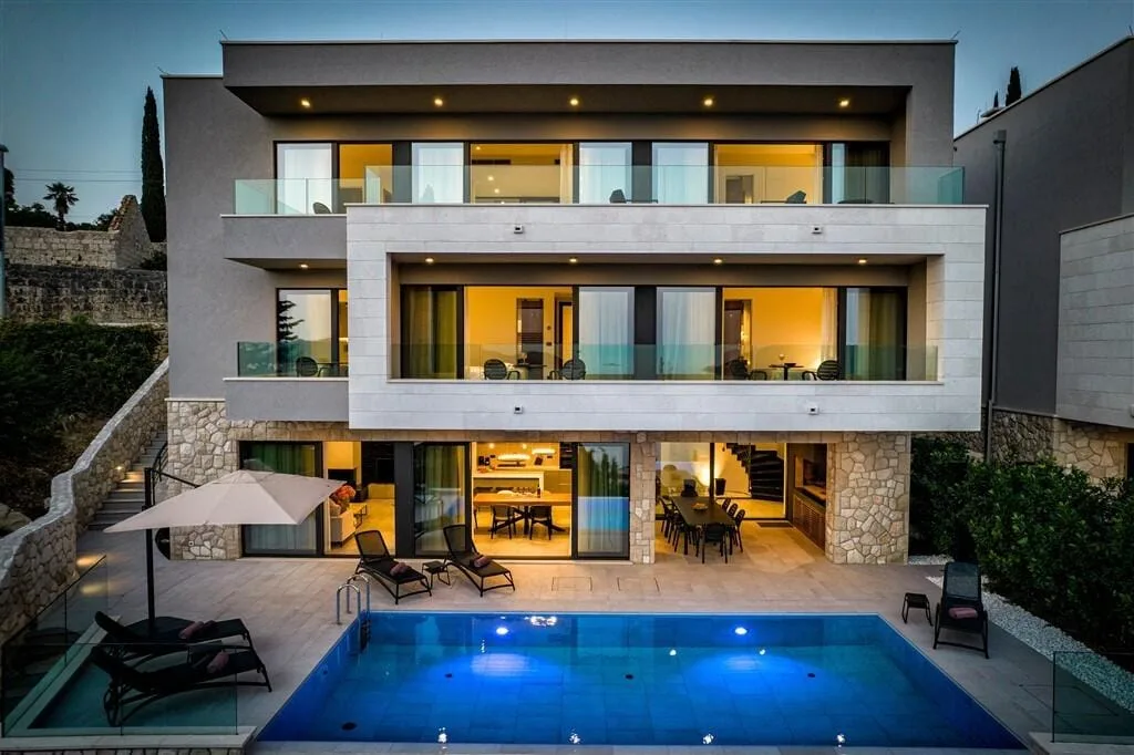 Contemporary Villa Monte with illuminated pool at dusk in Orašac near Dubrovnik