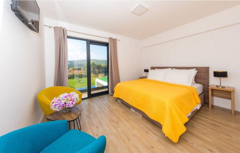 Bedroom with king-size bed and yellow bedspread at Villa Aether