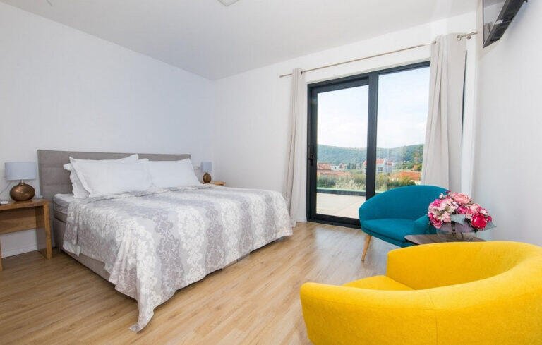 Bedroom with king-size bed and garden view at Villa Aether