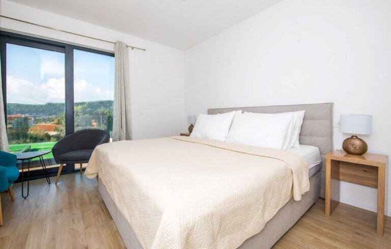 Bedroom with king-size bed and balcony door at Villa Aether
