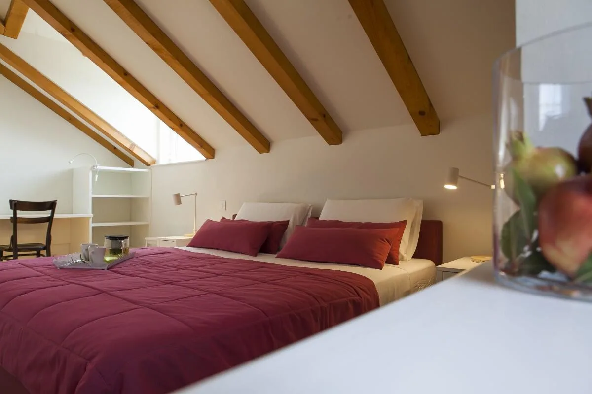 Bedroom with king-size bed under wooden beams at Villa Ella