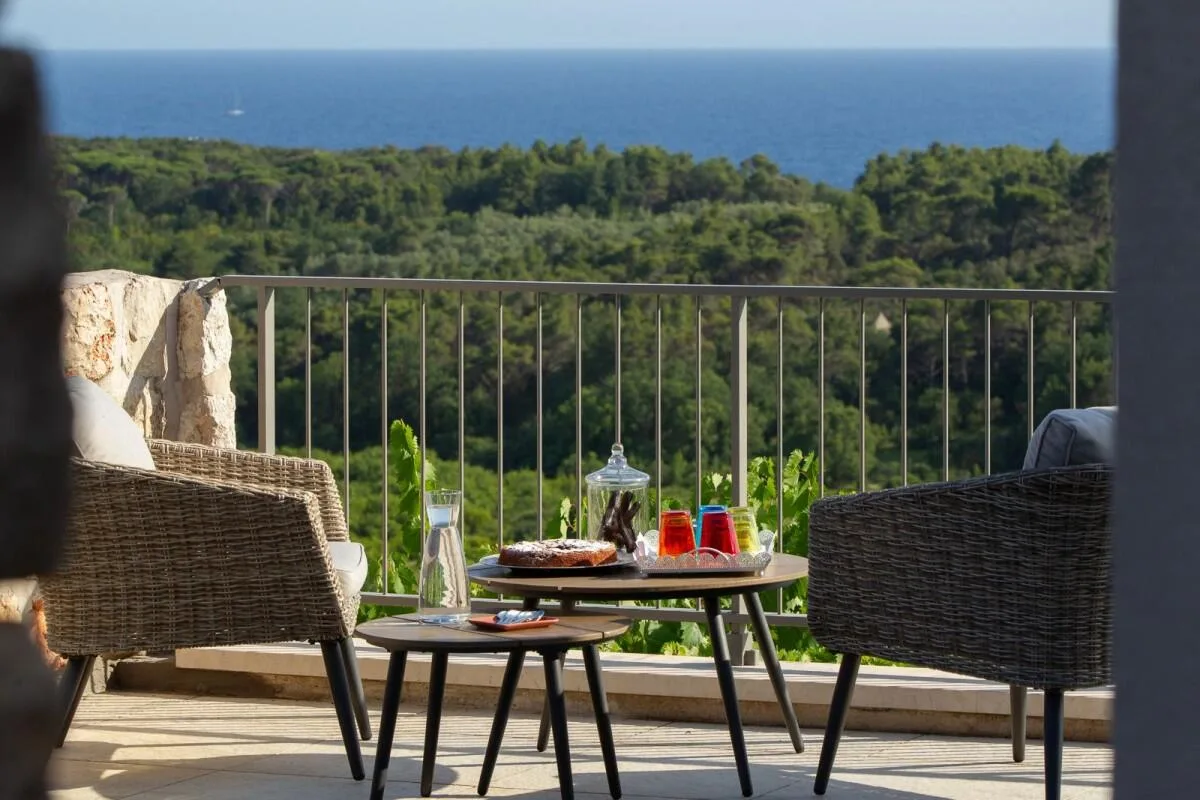 Balcony with armchairs and drinks overlooking the sea at Villa Ella