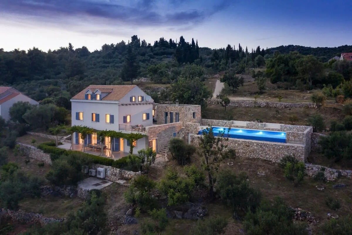 Aerial view of Villa Ella and illuminated pool at dusk on Šipan island