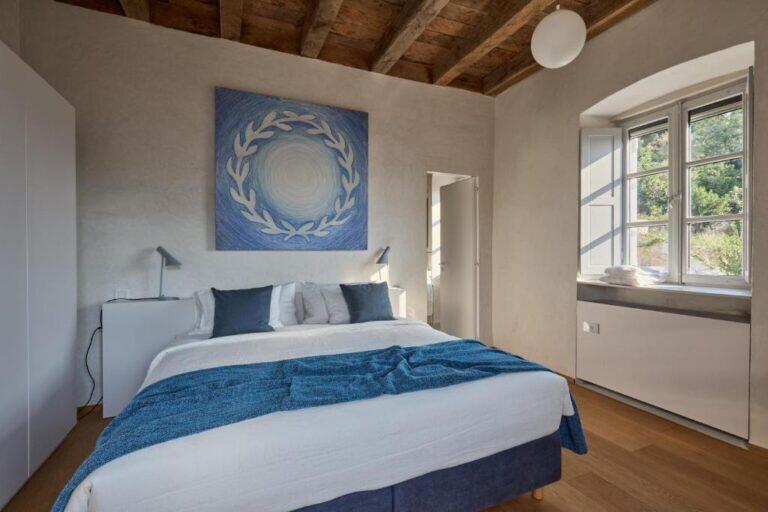 Schlafzimmer mit Kingsize-Bett und blauen Kunstwerken im Villa Ghetaldi 1516