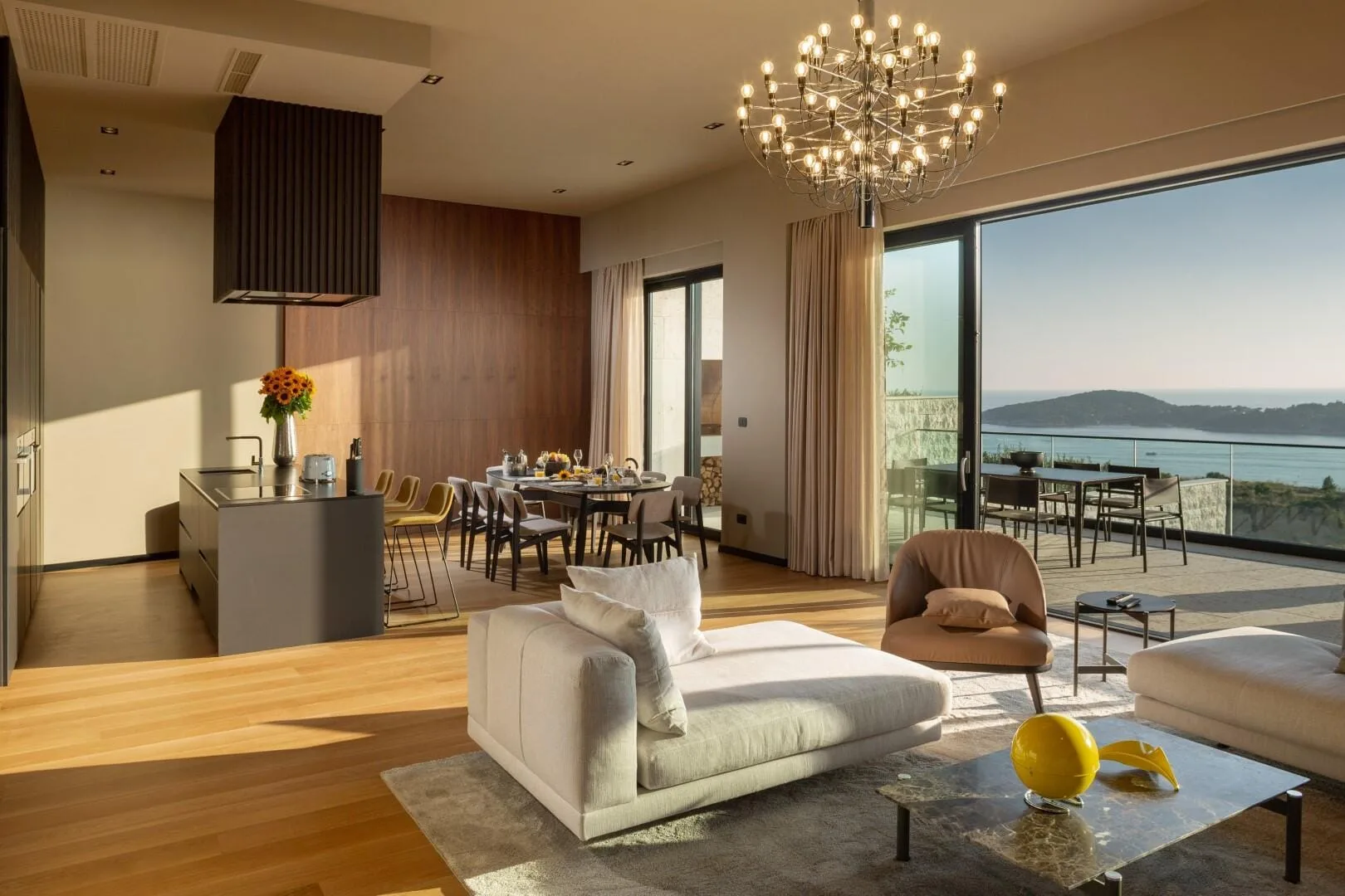 Open-plan living room with chandelier and sea views at Villa La Frida