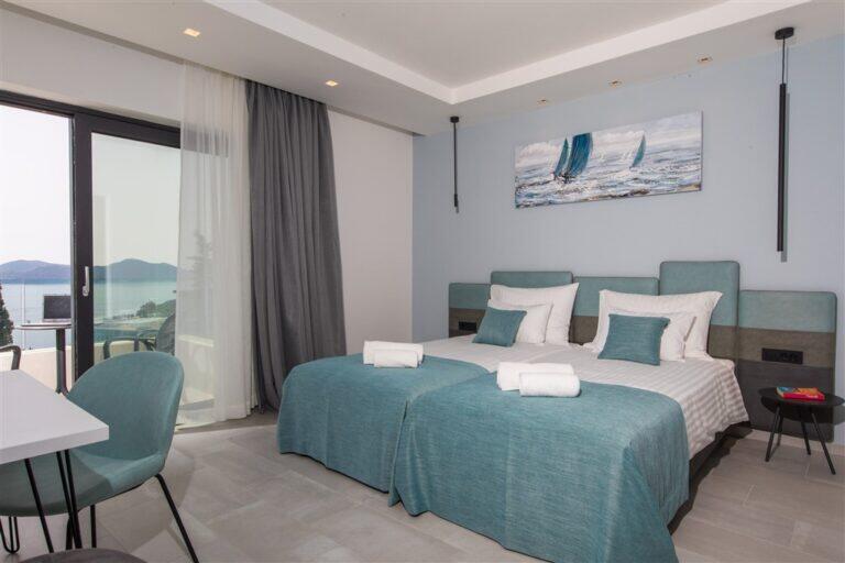 Schlafzimmer mit Kingsize-Bett und Teak-Bettwäsche in der Villa Monte