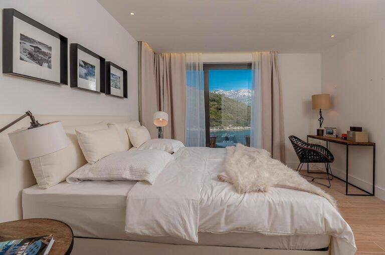 Bedroom with king-size bed and sea-view balcony at Villa Opus