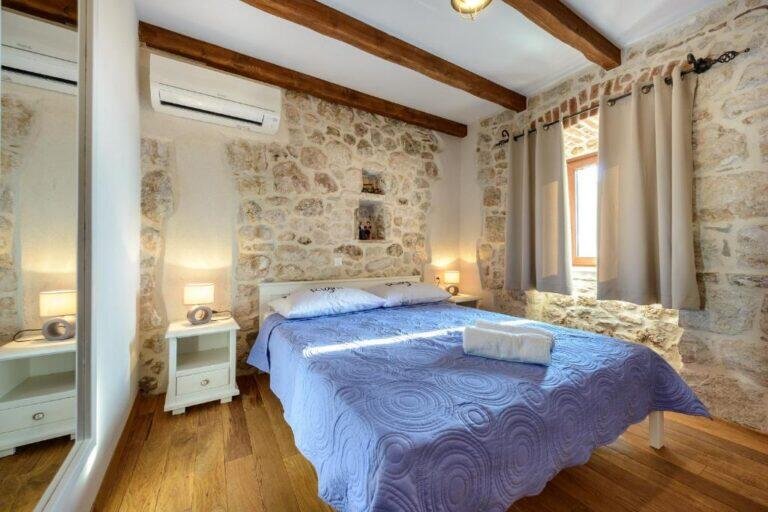 Bedroom with queen-size bed under wooden beams at Villa Zeus