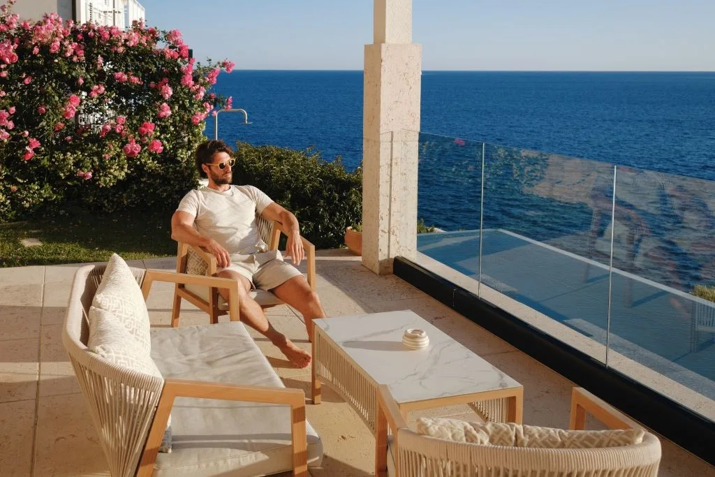 Guest relaxing on an outdoor sofa with sea view at Villa Moa