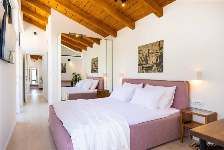 Schlafzimmer mit Kingsize-Bett und rosa Kopfteil in der Villa Moa