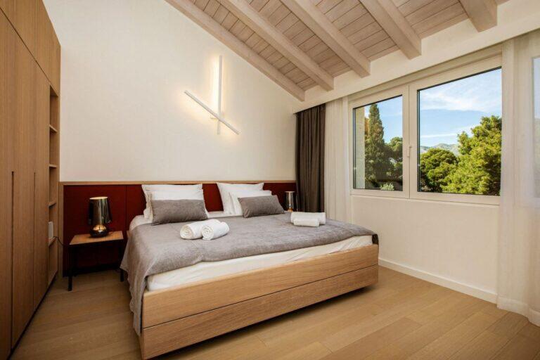 Schlafzimmer mit Kingsize-Bett unter einem schräg abfallenden Decken in der Villa Auna