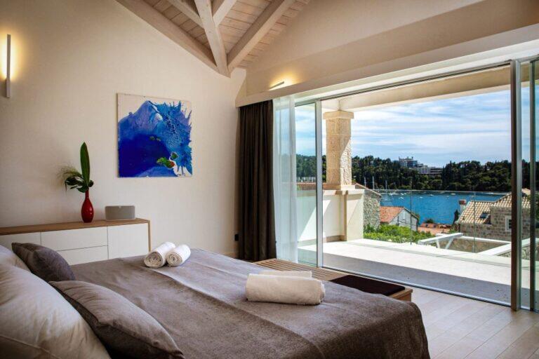 Schlafzimmer mit Kingsize-Bett und Balkon mit Meerblick in der Villa Auna