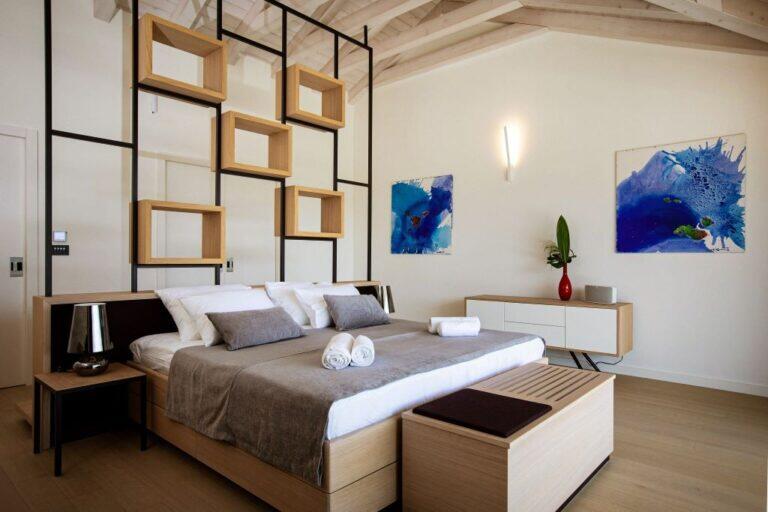 Schlafzimmer mit Kingsize-Bett und dekorativen Regalen in der Villa Auna