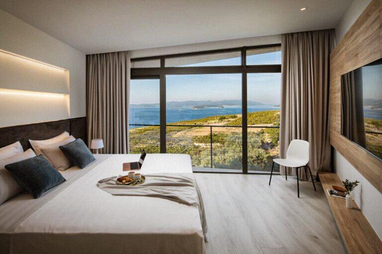 Schlafzimmer mit Kingsize-Bett und Fenstern mit Meerblick im House Bevel