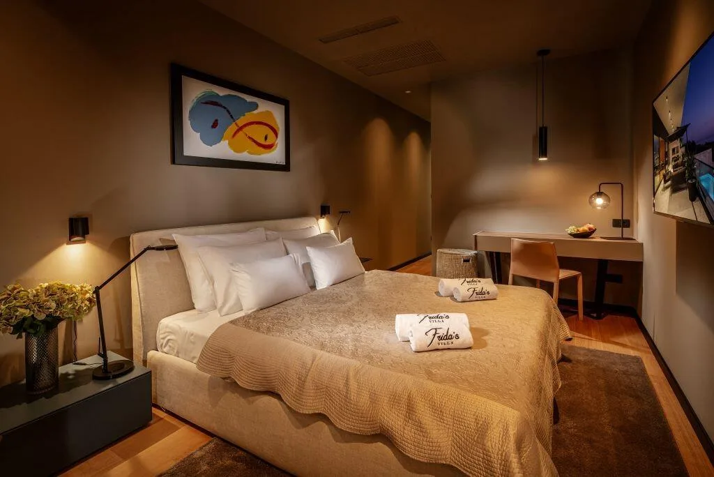 Bedroom with king-size bed and desk at Villa La Frida