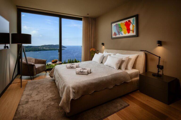 Schlafzimmer mit Kingsize-Bett und Fenster mit Meerblick in der Villa La Frida
