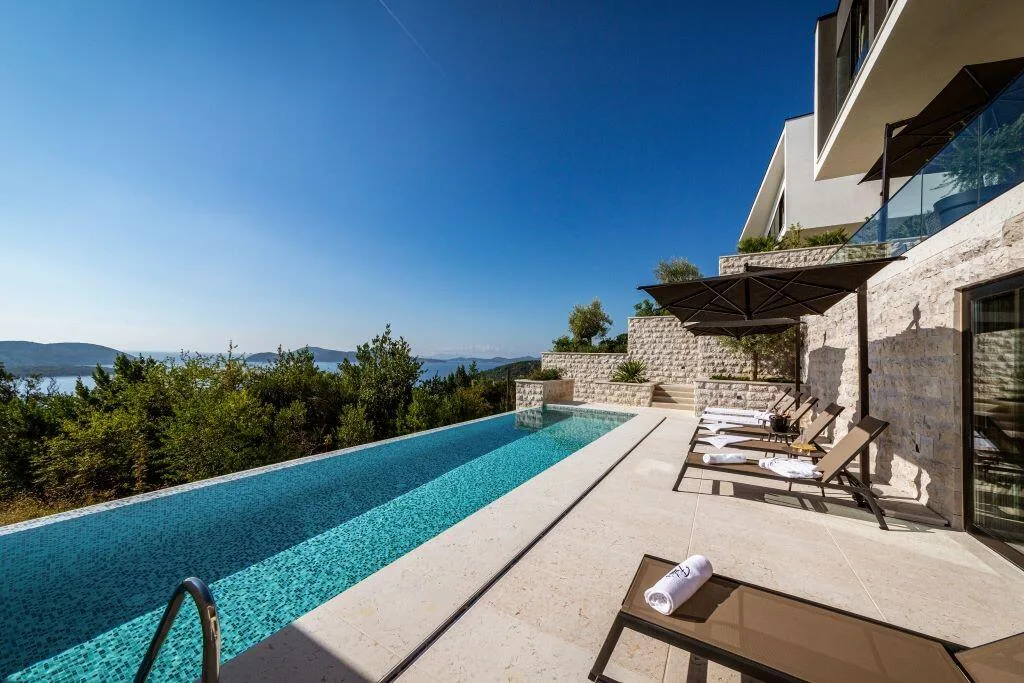 Long infinity pool with loungers and sea views at Villa La Frida