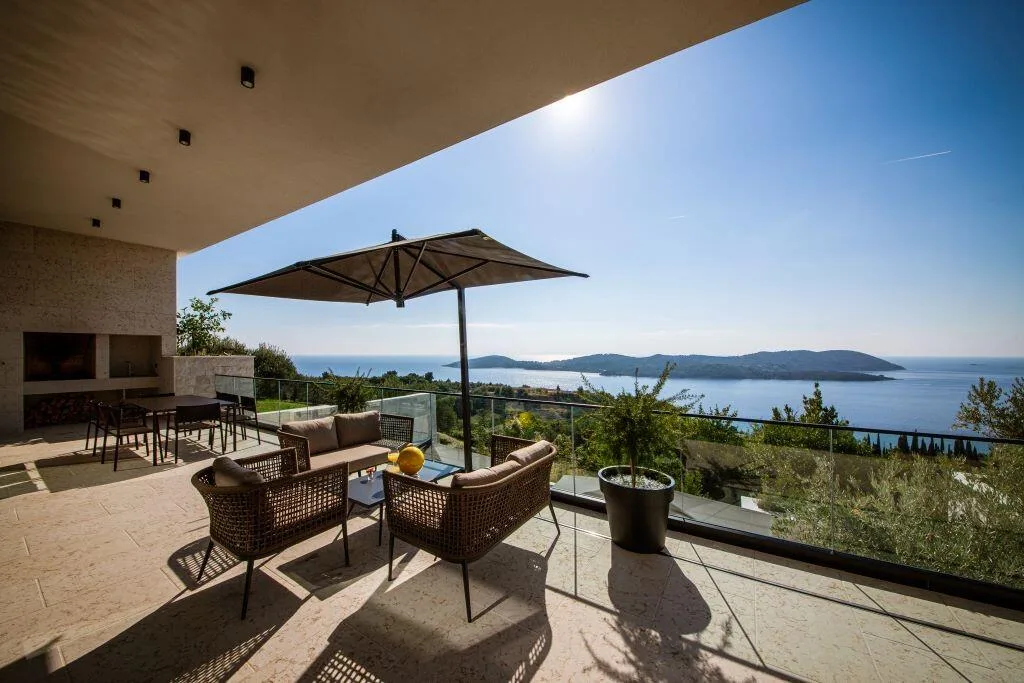 Terrace lounge with parasol and island views at Villa La Frida