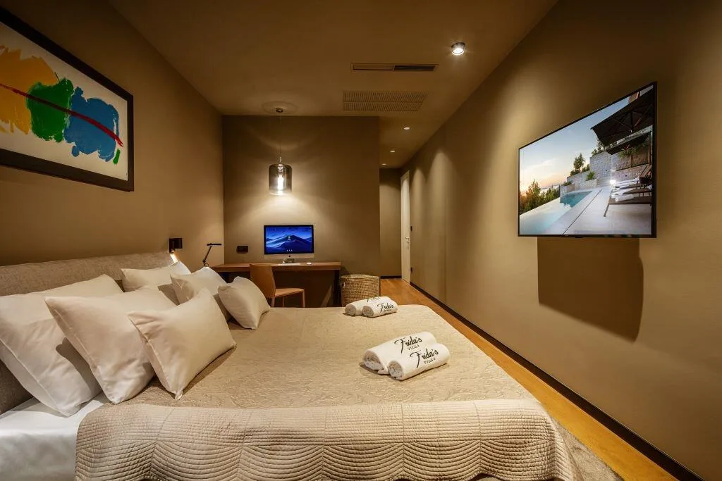 Bedroom with king-size bed and TV at Villa La Frida
