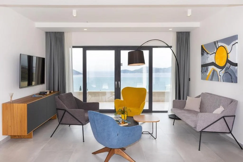 Living room with colourful armchairs and sea view at Villa Helia