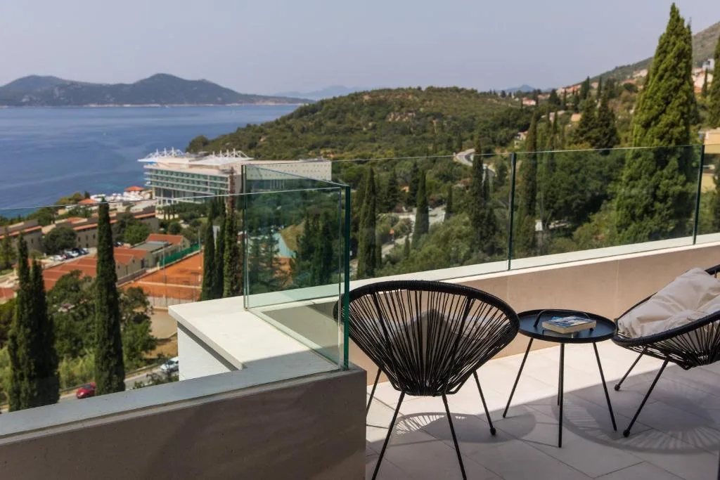 Balcony with chairs overlooking the coast and sea at Villa Helia
