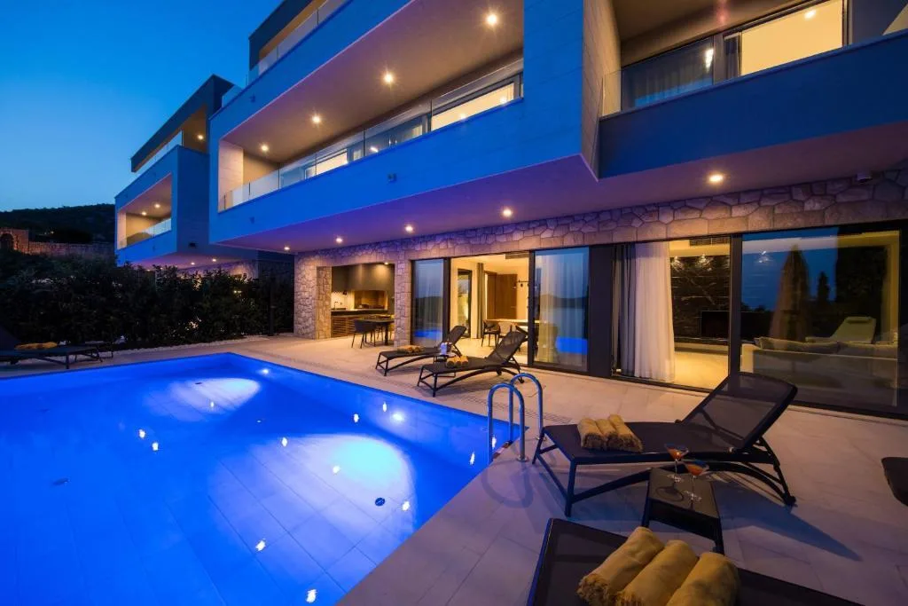Illuminated pool and terrace at night at Villa Helia