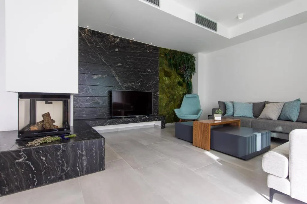 Living room with double-sided fireplace and marble wall at Villa Helia