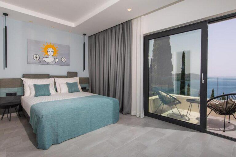 Schlafzimmer mit Kingsize-Bett und Balkontür mit Meerblick in der Villa Helia