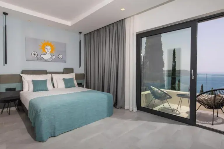 Bedroom with king-size bed and balcony door with sea view at Villa Helia