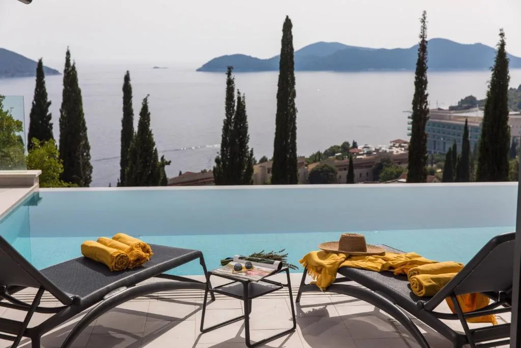 Infinity pool with cypress trees and Elafiti Islands view at Villa Helia