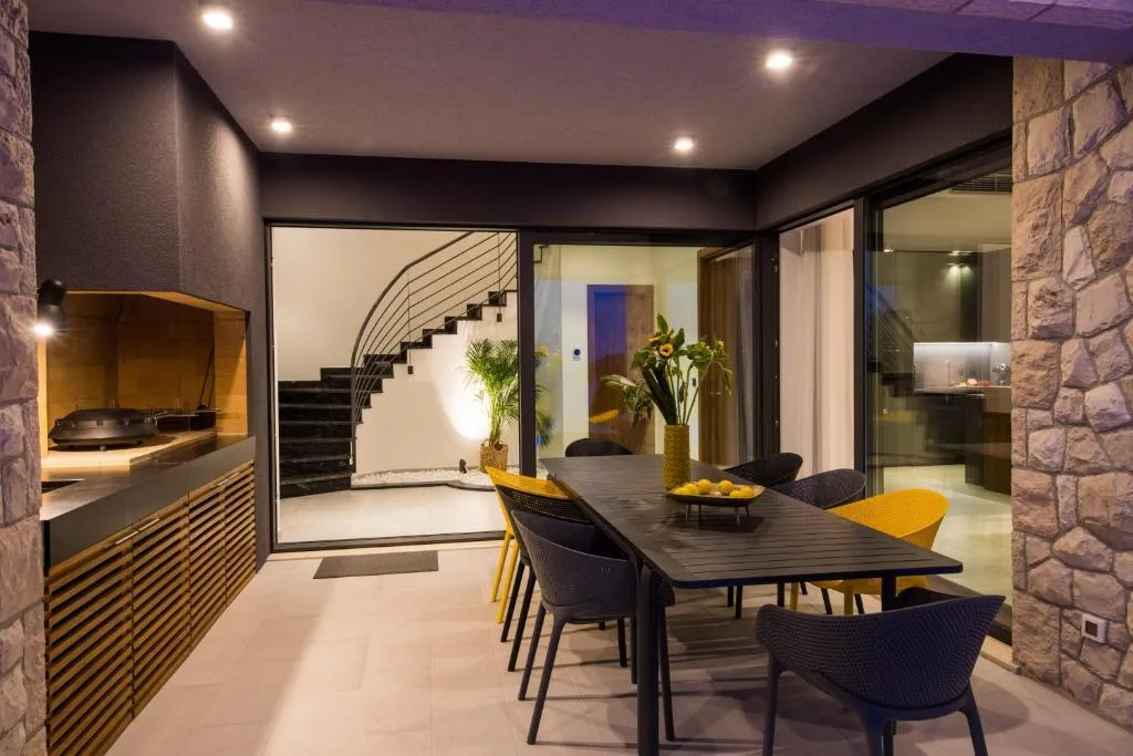 Covered outdoor dining area with barbecue at Villa Helia