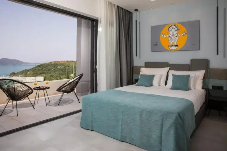 Bedroom with king-size bed opening onto a sea-view balcony at Villa Helia