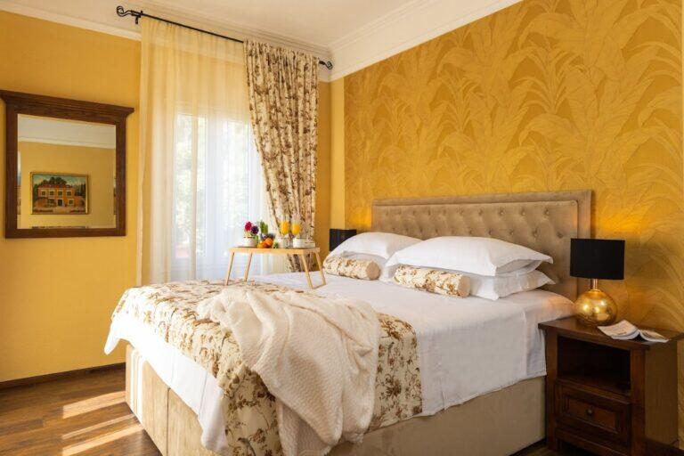 Schlafzimmer mit Doppelbett und gelben Wänden im Villa Le Jardin