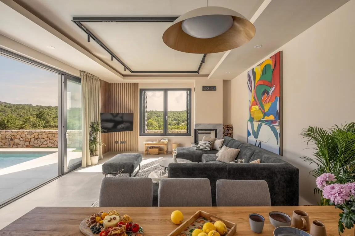 Living room with grey sofa and colourful painting at Villa Petra
