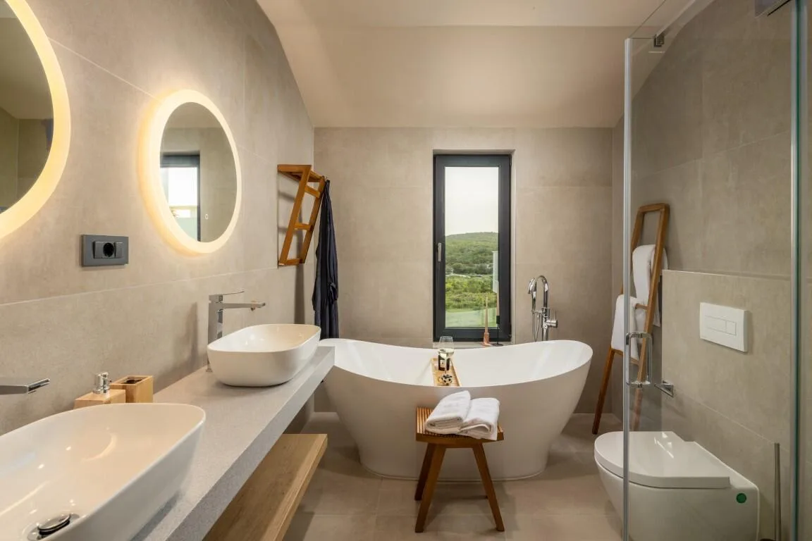 Bathroom with freestanding bathtub and backlit mirror at Villa Petra