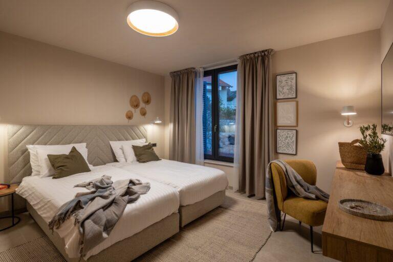 Schlafzimmer mit Kingsize-Bett und Lesestuhl in der Villa Petra