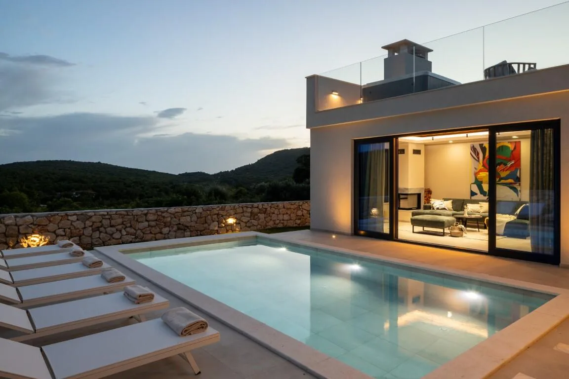 Pool and sun loungers at sunset with countryside views at Villa Petra