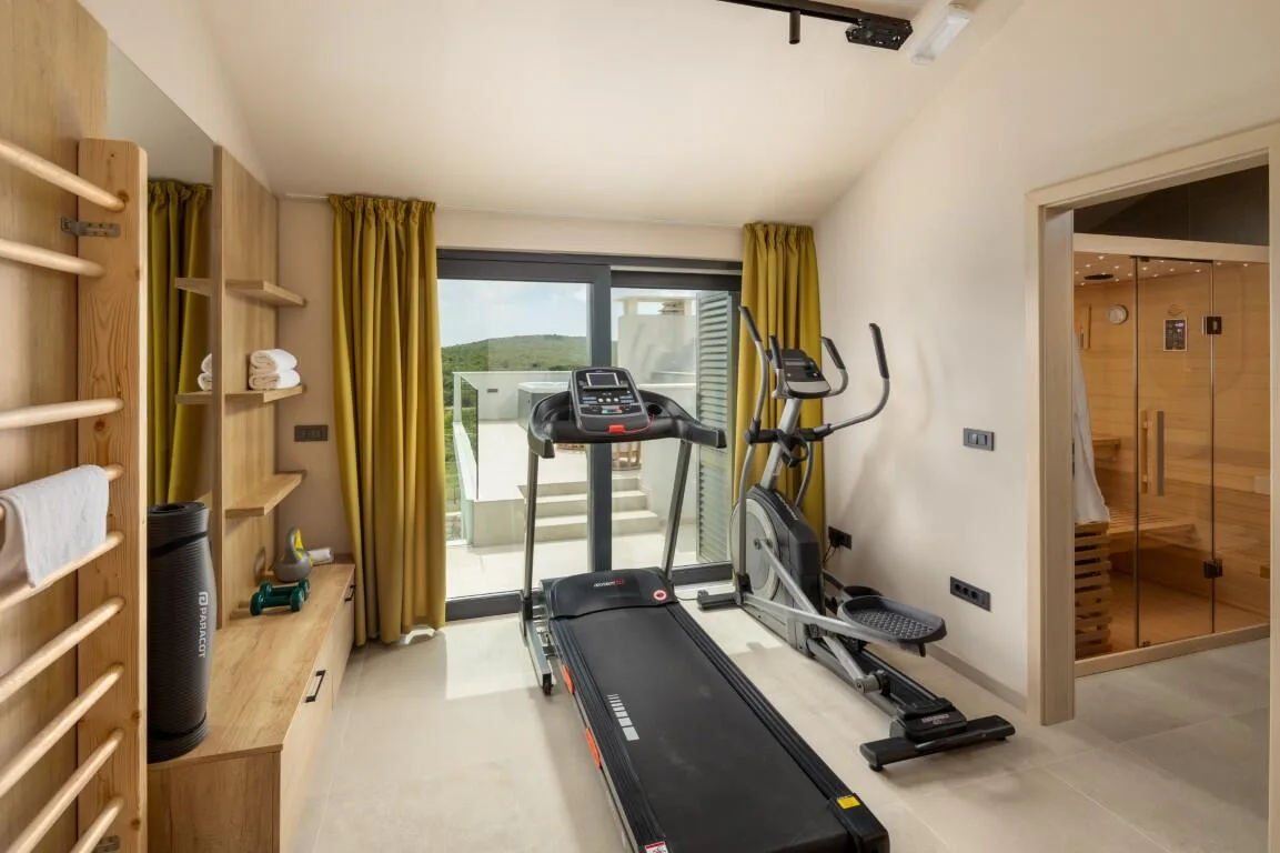 Home gym with treadmill and exercise bike at Villa Petra