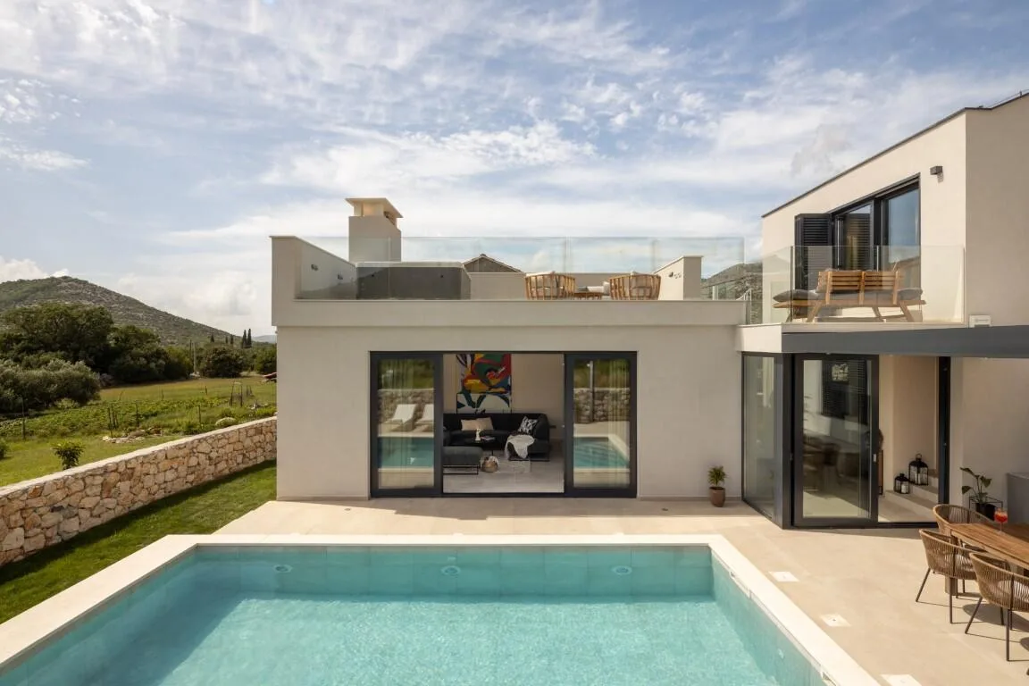 Rear view of Villa Petra with pool, terraces and stone wall
