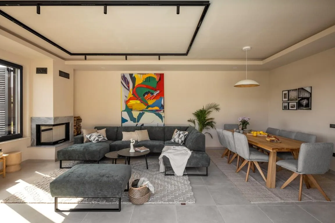 Open-plan living room with sofas, colourful artwork and dining table at Villa Petra
