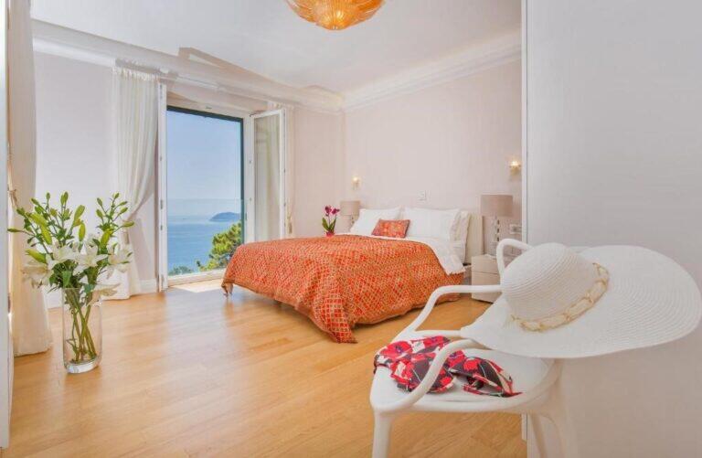 Schlafzimmer mit Doppelbett und Balkon mit Meerblick in der Villa Vintage