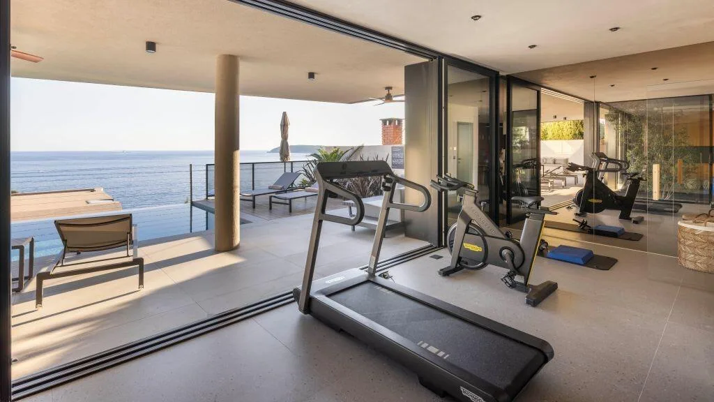 Private gym with treadmill and bike facing the sea at Villa Atreeum