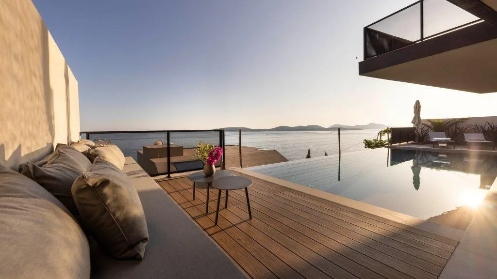 Lounge cushions on the pool deck with sea views at Villa Atreeum