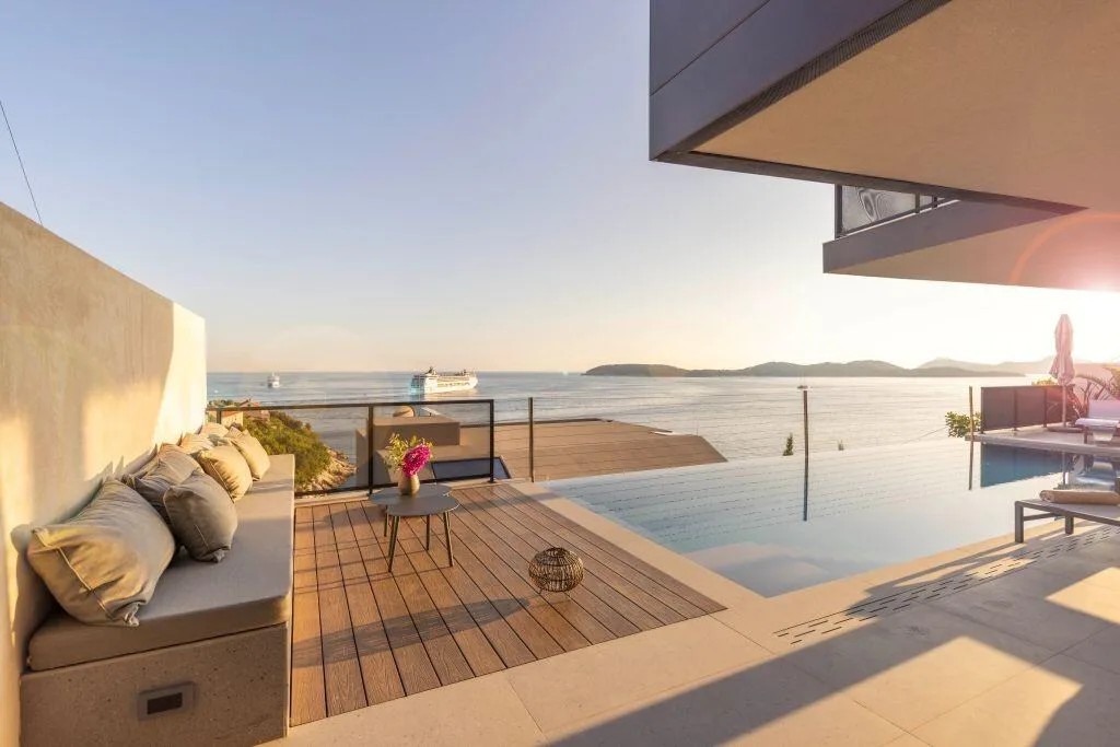 Wooden sun deck with cushions beside the infinity pool at Villa Atreeum